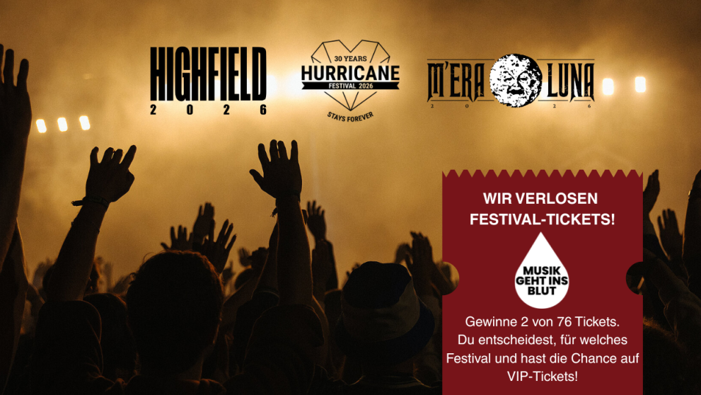 Eine Festival-Crowd vor einer Bühne, die die Hände in den Himmel hält.