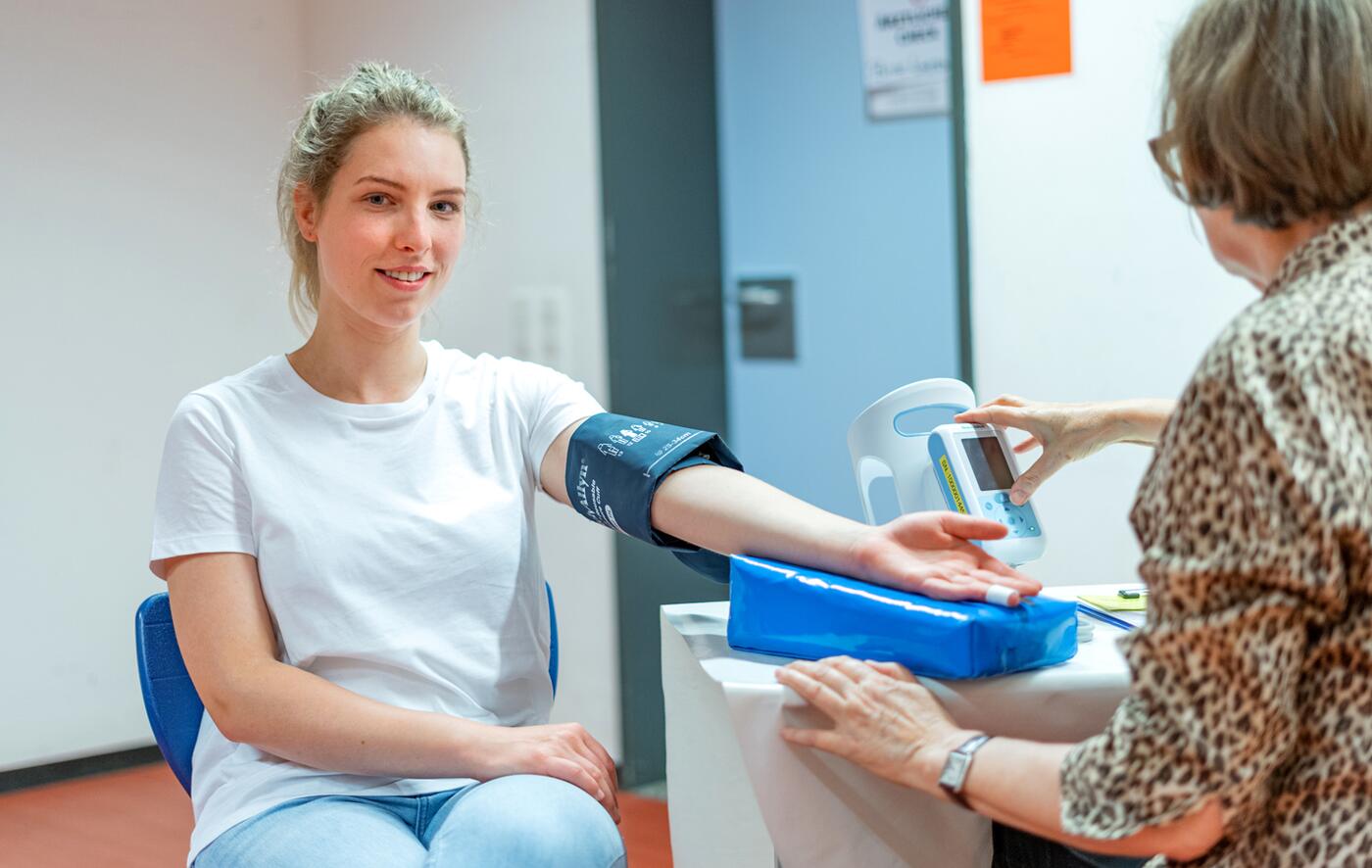 Blutspenderin wird beim Arzt-Check der Blutdruck gemessen