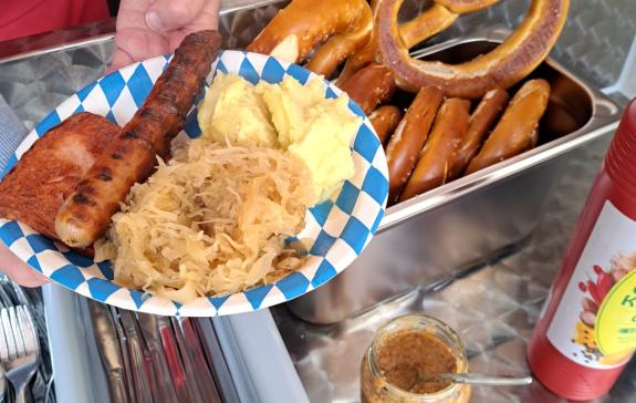 Zu sehen ist ein Teller mit Bratwurst, Sauerkraut und Kartoffelbrei