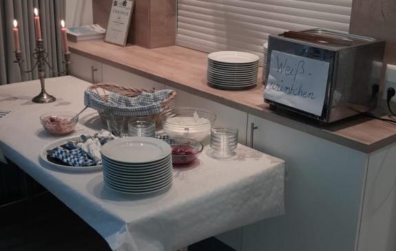 Zu sehen ist ein schöner Tisch mit bayrischem Buffet und Kerzenlicht