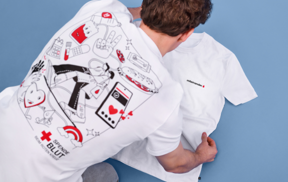 Ein Mann, der ein weißes T-Shirt mit einem auffälligen Backprint trägt.